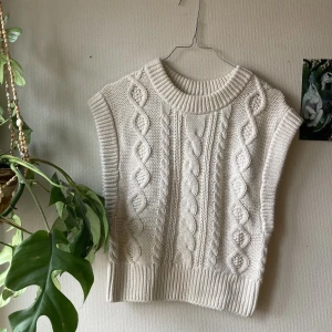 Stickad vit väst	 - Mysig och snygg stickad väst med flätor.