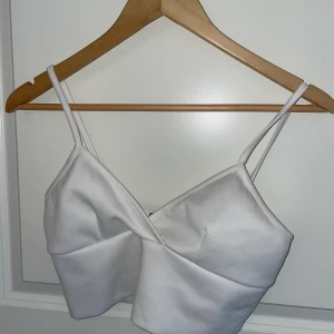 Vit sommartopp - Så snygg sommartopp. Vit, tjockt material med bra kvalitet. Fint skick. Sitter jättebra över både små och större bröst 