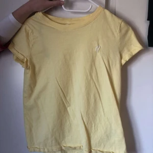 Gul T-shirt  - Söt T-shirt från HM med ett litet broderat hjärta över ena bröstet. Inget fel på plagget!