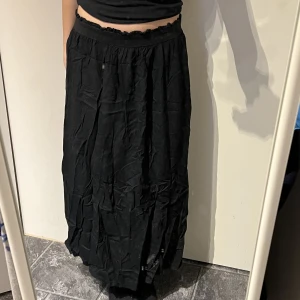 Lång kjol - Lång svart kjol från ONLY. Den är väldigt fin (särkilt om man stryker den hihi) och bekväm. Knappt använd! Man kan ha den både lågmidjat och högre upp. Resårbandet i midjan är stretchigt så skulle säga att storleken är s-l.