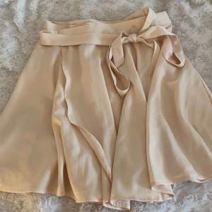 En jättefin kjol i satin, köptes i bikbok men kommer inte till användning, storlek XS men passar även S eftersom den går att knyta hur man vill 💕 kan mötas i göteborg annars står köparen för frakt!