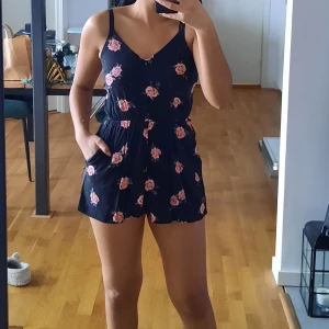  Jumpsuit/romper - En kort romper med blommigt mönster. Säljer då den blivit för liten på mig.