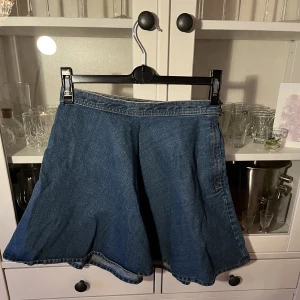 Jeanskjol - Häftig jeanskjol från Monki, i snygg utsväng modell. Klassisk denim blå, strl 36. Bra skick. 