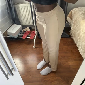 Beige Kostymbyxor - Stretchiga kostymbyxor med slits. Dessa byxor är för korta för mig därför säljer jag dem. Sömmen har gått upp lite vid rumpan, därav det försänkta priset, men bortsett från det finns det inga synliga fel. Skriv för mer bilder💛