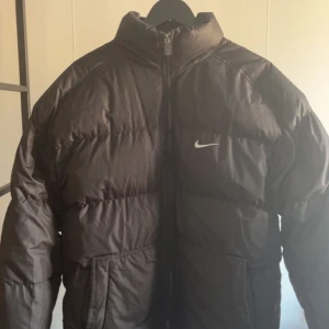 Vintage Nike Puffer jacket - Skit snygg vintage jacka, fint skick (8,5/10) litet litet hål vid högra fickan och lite lite slitage högst upp vid dragkedjan.  Den sitter stort på mig jag är 175, skulle säga att den skulle sitta perfekt på någon runt 178+ 