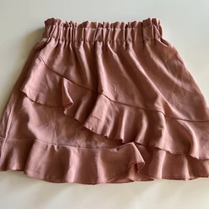 Volang kjol - Volangkjol som tyvärr inte kommer till användning. Super fin rosa färg, som är lite mörkare på bild. Tyvärr ingen lapp på, men skulle säga att den passar xs/s/m eftersom den är töjbar och har en resår. 