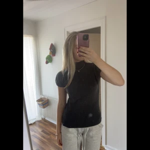 Mörkgrå topp - En snygg mörkgrå topp med en polokrage och en öppning där bak! Formsr sig efter din kropp💗💗