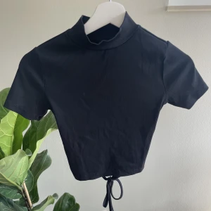 T-shirt - Ribbad svart t-shirt med krage och öppen i ryggen. I storlek S från Gina Tricot😊