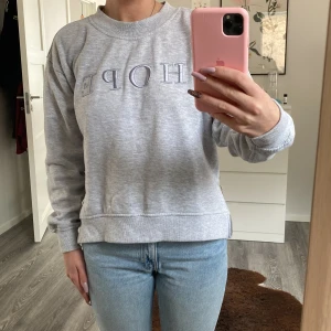 Sweatshirt  - En fin grå sweatshirt med texten HOPE broderad fram och dragkedjor på sidan