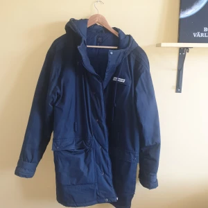 Stor marinblå adidas - Storlek XL. Fodrad på insidan. Stora fickor. Luva.