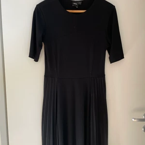 Svart klänning med plisserad detalj - Svart klänning, plisserad i sidorna liksom. Bra skick! Obs hund finns i hemmet.