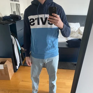 Levis hoodie färgblock blå/vit - Säljer denna snygga hoodie från Levis då den inte kommer till användning längre. Storlek M i väldigt fint skick!