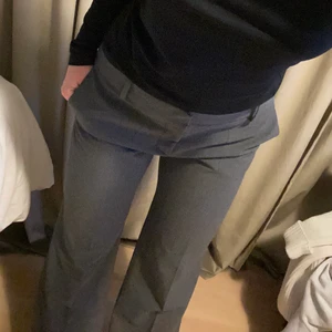 Grå lågmidjade kostymbyxor  - Grå lågmidjade kostymbyxor, köpta second hand men bara använd nån gång av mig och finns inga defekter. Så bra skick! storlek 38 men jag är mer 36 så skulle säga de är ganska små i storleken. Är 165 cm lång och de är lite för långa, går dessutom att sprätta upp där nere så de blir kanske 2 cm längre. Om många är intresserade startar jag budgivning! skriv privat för svar på frågor eller fler bilder