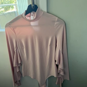 Festbody från NLY ONE - Knappt använd Body från Nelly. Den är puderrosa med massor av fina detaljer! Tyget känns väldigt exklusivt. Det är en Body man knäpper samt så är den med string. 