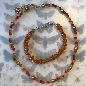 Halsband och armband - Ett set av ett halsband och ett armband i typ orange, som jag gjort själv. Smyckena säljs inte separat. Maxlängden på armbandet är 19cm och halsbandets maxlängd är 40cm. Om du önskar att jag ska lägga till/ta bort ett par länkar är det bara att säga till