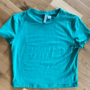 Grön T-shirt från H&M - Grön T-shirt från H&M storlek M. Croppad och aldrig använd. 