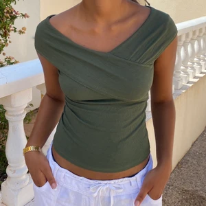 grön ribbad topp - grön ribbad topp där ”ärmarna” korsar varandra! så skön och fin! passar året runt🌏 har lite dåliga sömmar på två ställe men annars bra skick! stl saknas men uppskattas till 38, S/M!🖤 har en likadan i svart♥️💚 (se bio för övrig info)