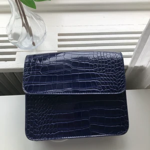 Clutch från Hvisk - En marinblå clutch från Hvisk, från början en axelväska men axelremmen har gått av. Sedan dess har jag använd den som en clutch, alternativt ha ett annat/eget axelband. Väl använd, se bilder. Fraktar eller möts upp i Gbg. 