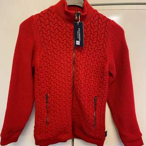 Helt ny Vindfordrad stickad tröja, röd, i stl S. Nypris 1245kr.