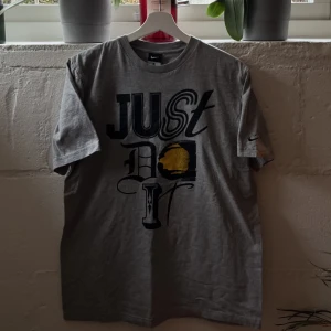 Nike t-shirt - L - Nike t-shirt i storlek L. Överfet Nike logga på höger sida. Grå färg och tröjan är i toppklass skick!