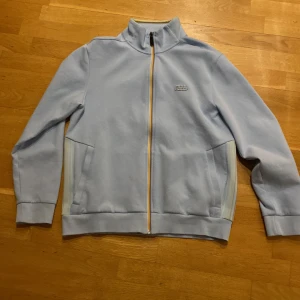 Boss zip tröja - En boss tröja jag köpte i somras för 2000 kr. Inte använd mycket alls och jag säljer den för bra pris för får inte sålt den.mer information så skriv till mig.