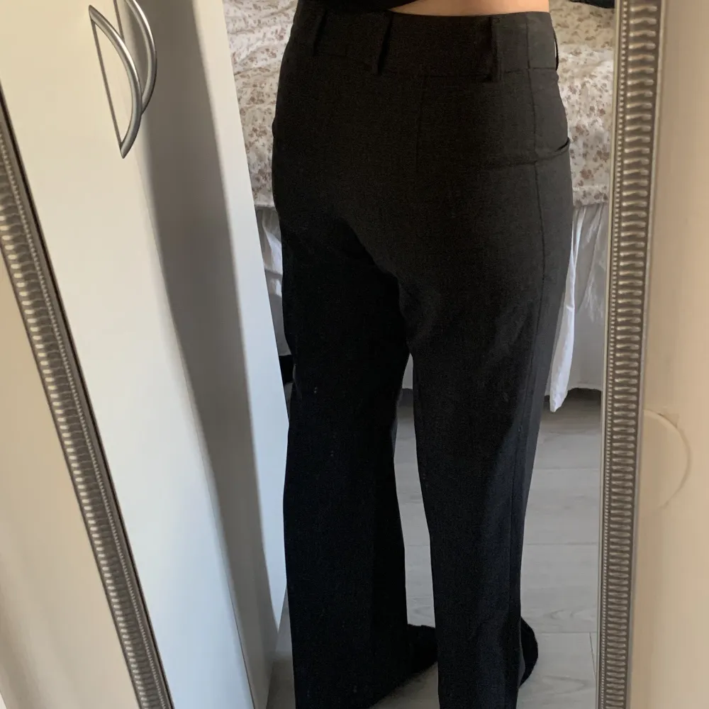 Säljer dessa mörkgråa low waist kostymbyxor som är köpa på secondhand. Längden är bra på mig som är 170cm lång!. Jeans & Byxor.