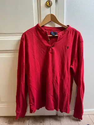 Röd långärmad tröja med svart märke. Kondition 10/10 knappt använd 
