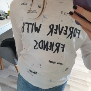 Långärmad tröja - Långärmad vit tröja med svart text och blåa detaljer. Ifrån name it. Texten i mitten är lite glittrig. Säljer den pga att den är för liten