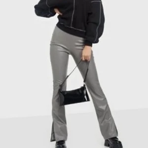 Grå skinnbyxor från Nelly - Säljer dessa PU-byxor från Nelly (utan slits!). På de två första bilderna ser ni färgen men på den sista ser ni modellen fast i färgen svart! Säljs inte längre på hemsidan ✨ Köparen står för frakten!
