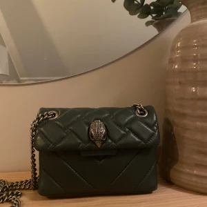 Grön Kurt Geiger väska  - Säljer den populära väskan från Kurt Geiger i mörkgrönt. Köparen står för frakt. Väskan är i använt skick💕💕det är den mindre storleken 