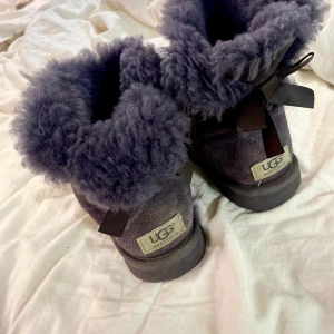 Uggs med roset strl 36  - Väldigt sköna Lila Uggs i strl 36  rosetet där bak. Vinterskor som känns som tofflor 