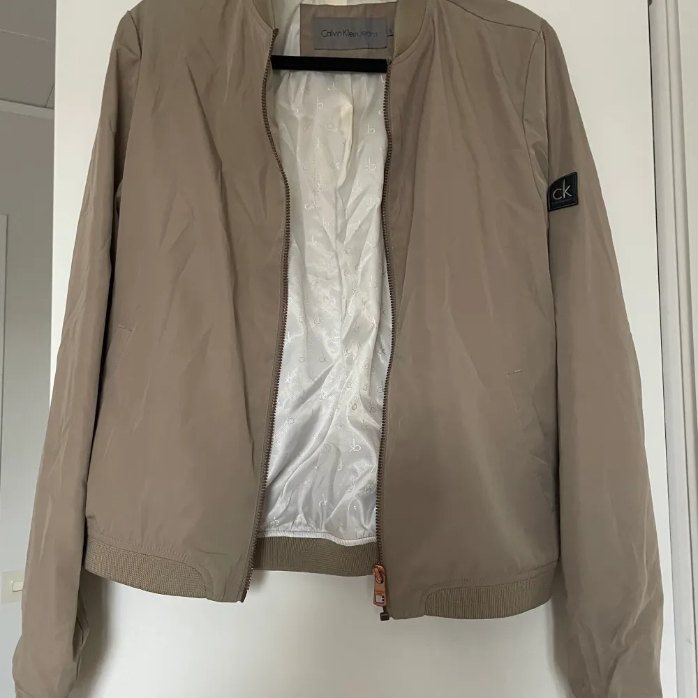 Calvin klein jacka i beige. Bomber jacka. Sparsamt använd. Storlek S. Köparen står för frakt.. Jackor.