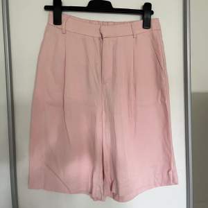 Rosa shorts i en längre modell från Gina Tricot, storlek 36. Shortsen är nästintill oanvända.