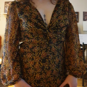 Jumpsuit  - Retroblommig jumsuit! Skön och luftig. Transparenta ärmar. Oanvänd!  Mått: axlar 40, under byst 38, ärm 60, längd från under byst 106. Jag är 175 cm lång och den sitter bra.