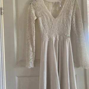 Klänning  - Ben vit klänning med spets och knytning i midjan. 