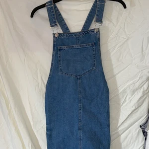 Blå Jeansklännig  - Söt blå jeansklännig från Primark, oanvänd, med ficka på bröstet och två fickor på sidorna, 