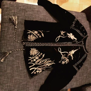 Svart kofta med guld detaljer  - Gulddetaljer och tofsar där nere. Kofta I sammet