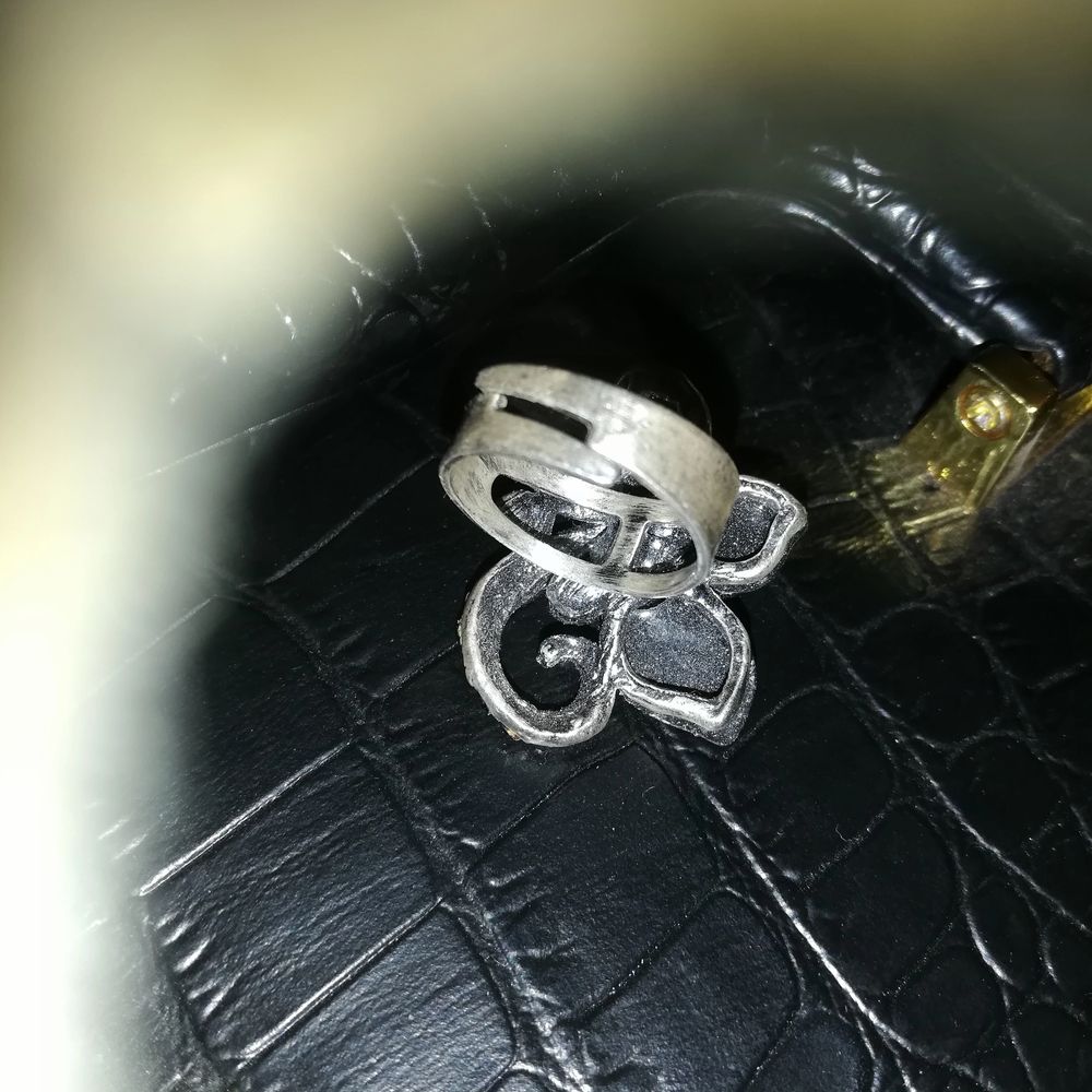 Stelbar ring med halv svart bloma med olika glitter stenar svarta en vit o en grå ut smyckat med fina detaljer 50kr trakt till komer . Accessoarer.