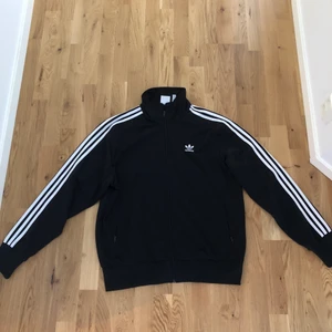 Adidas track top - En riktigt snygg track suit överdel från adidas, den är köpt för ett antal år sedan men har bara använt den ett fåtal gånger. Plagget är normal i storleken och passar båda kön