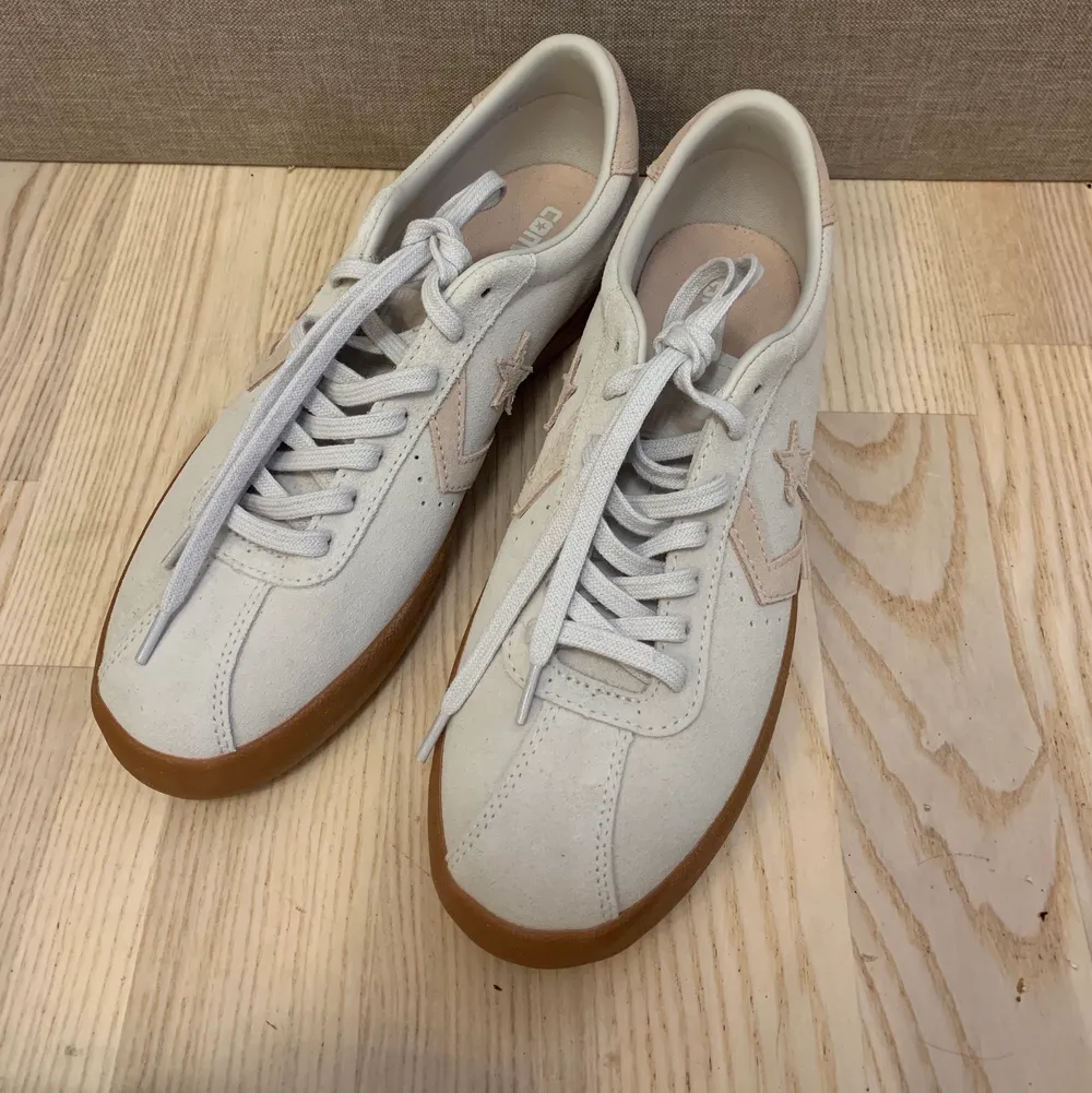 Beige/offwhite converse med rosa beiga detaljer, färgen i bilden är lite mindre rosa än de är i verkligheten.  Aldrig använda endast provade. Storlek 41 men skulle säga att de är lite små i storleken. . Skor.