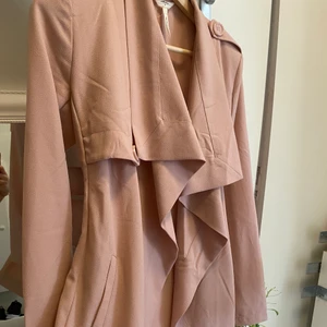 Kappa  - Säljer en rosa kappa som bara har legat i garderoben, den har aldrig använts lite skrynklig bara annars super fin rosa färg. Man kan även knyta kappan där framme och där bak man bestämmer själv