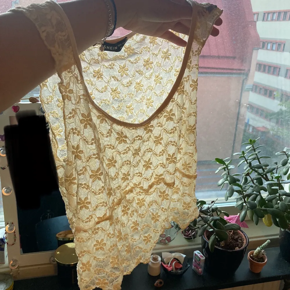 Beiget linne från shein som är genomskinligt med blommor på. T-shirts.