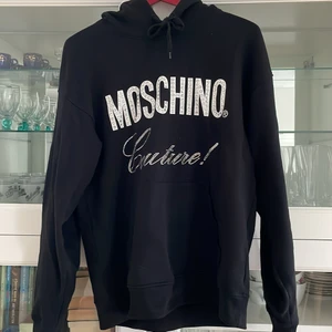 Moschino Hoodie strl 48/M - Hoodie av märket Moshino köpt på Thernlunds. Använt ett fåtal gånger men fortfarande  i nyskick och ej tvättad utan bara vädrad Nypris 5500