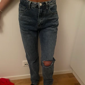 Blåa jeans - ”baggy” jeans i en typ av mörkblå färg. Köpta från SHEIN och är i storlek XS. Den har ett hål i knät framtill men även ett hål i knät baktill. (Dem är stylade så, ingenting jag har gjort själv). Dem sitter lite löst på mig som är XS. Säljer för 100kr👖