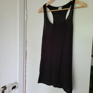 Linne svart stlM - Svart tunnt, lite längre linne. Snyggt att stopp in i jeansen tex. eller ha till yogapants! Skön viskos. Stl.M. Välvårdat och fint, men tyvärr används det inte löngre.