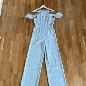 Blå jumpsuit - Fin Ljusblå jumpsuit med öppna axlar. Använd 1 gång! 