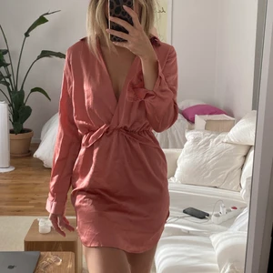 Satin klänning från Pretty little things - Smutsrosa satin klänning från Prettylittlethings med volangliknande resår i midjan. Storlek: 36 