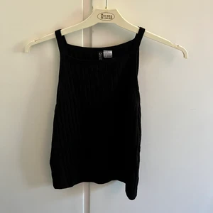 En svart topp - En fin ribbat linne som kan vara fint att matcha med ett par byxor eller en kjol.