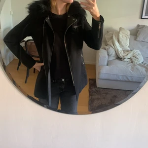 SVART KAPPA MED AVTAGBAR PÄLS 36 - Svart kappa från Nelly. Storlek 36, pälsen kan man ta av med knappar. Använd fåtal gånger. 