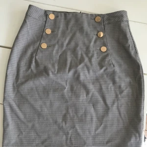 Kjol  - Kjol som ny rutig med knappar som fina detaljer fram i guld .